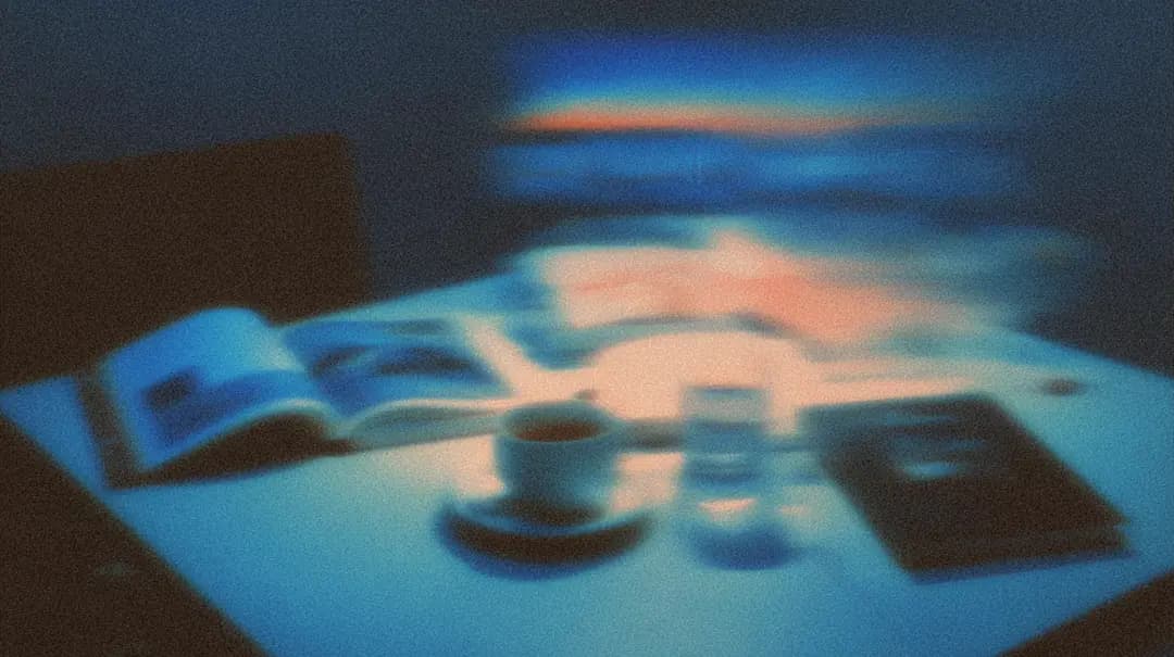 Softly lit table with an open book and coffee